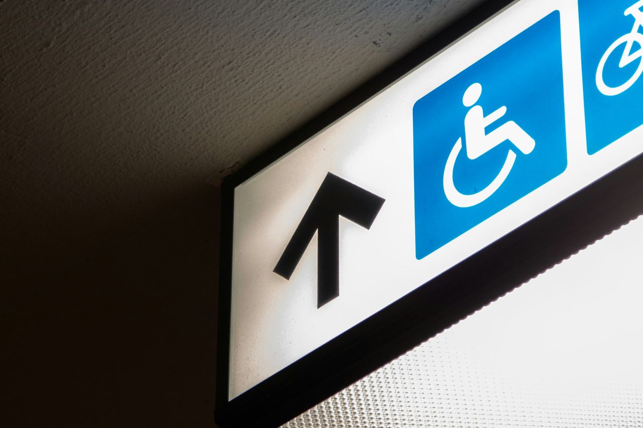 Un panneau lumineux de signalisation indiquant un accès réservé aux personnes en fauteuil roulant.